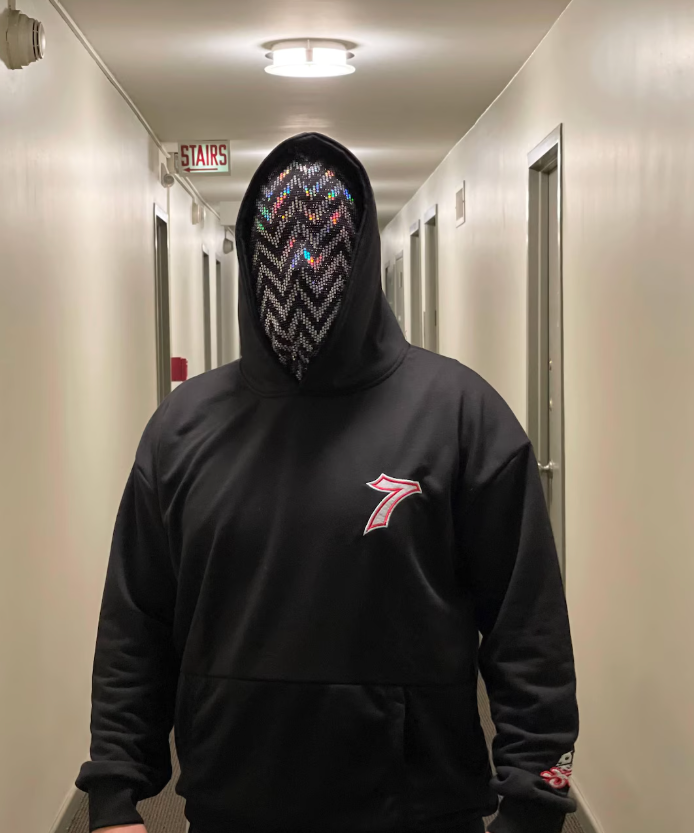 OTKYDACH holographic full face balaclava with reflective chevron pattern worn with a black hoodie, showing the mask under indoor lighting