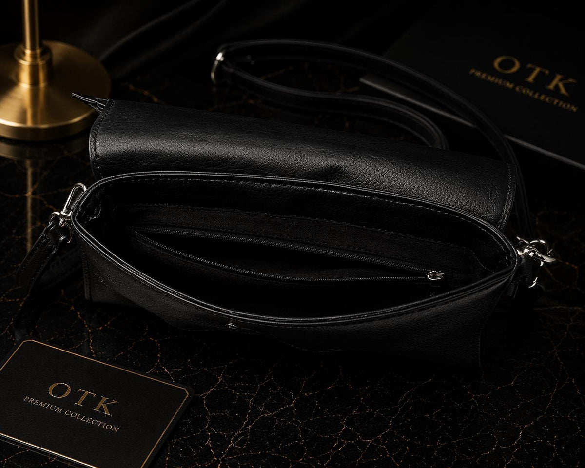 Open black bat wing bag showing interior zip pocket and fold-over flap